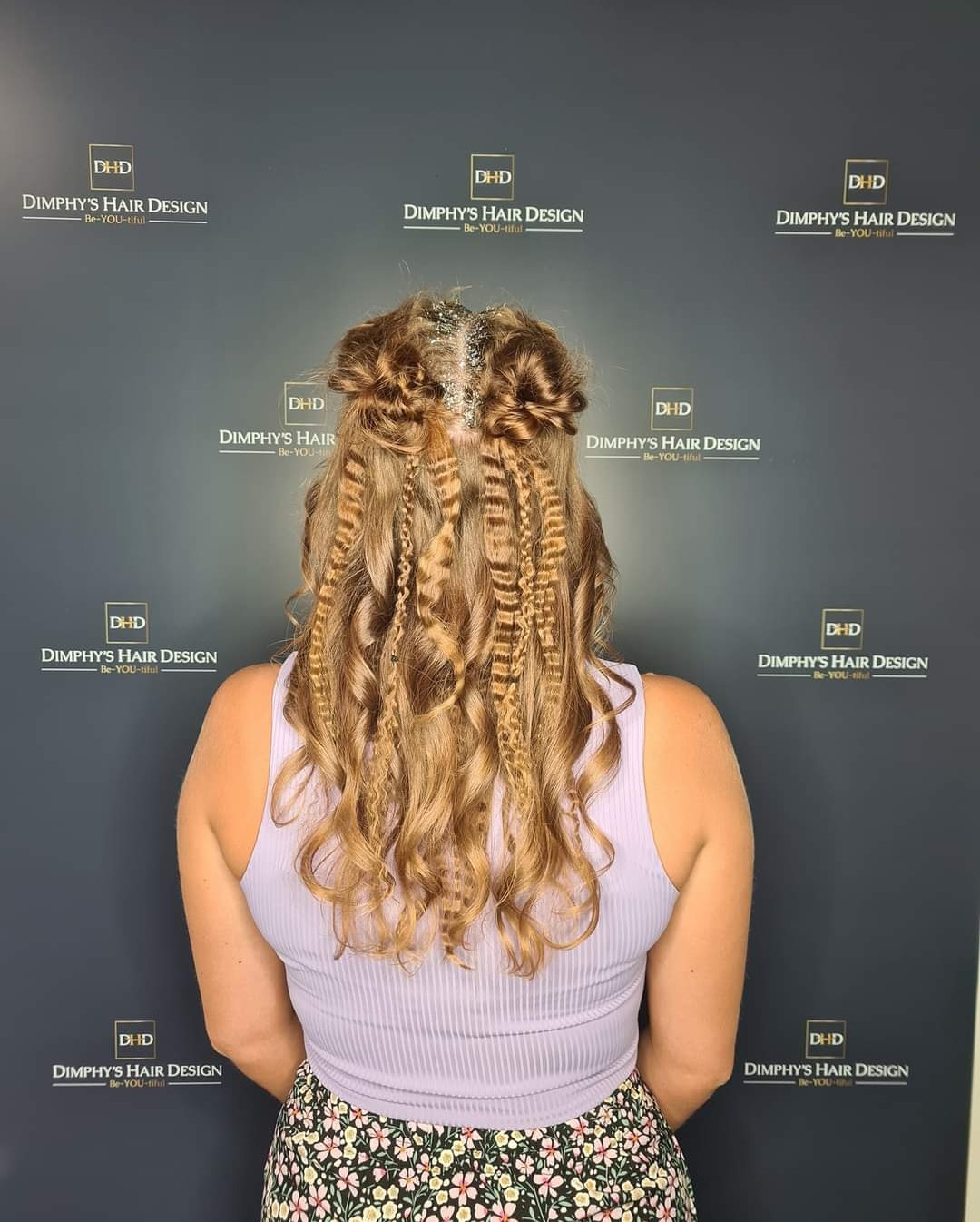 Lang haar half opgestoken met vlechten en krullen, van achteren, voor de logowand