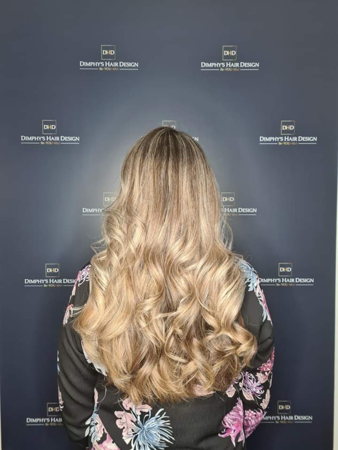Lang honingblond haar in slagen, van achteren, voor de logowand